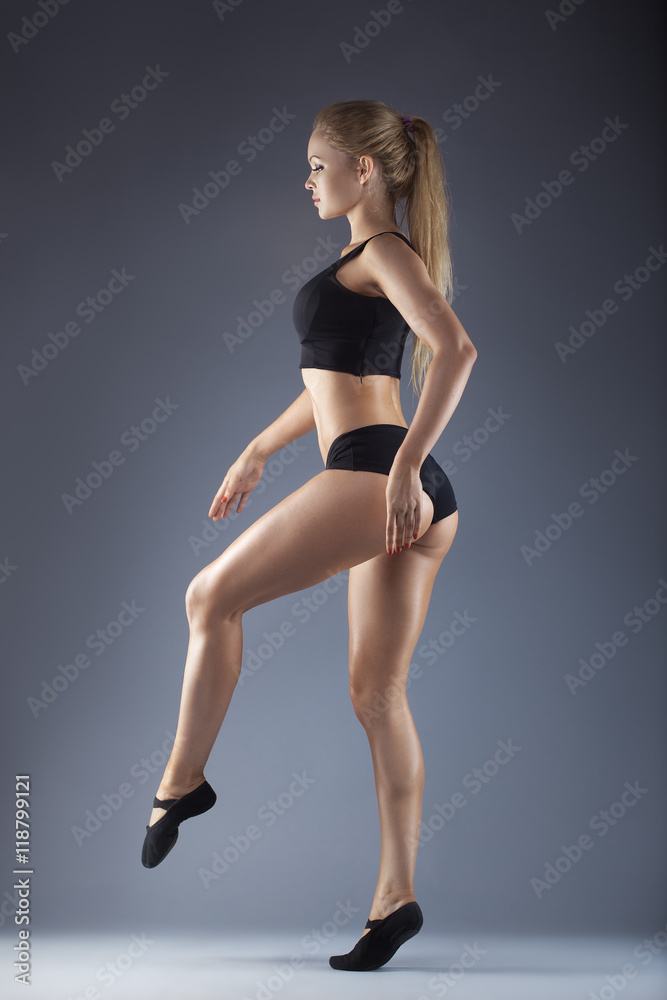 Young beautiful dancer posing on a studio background