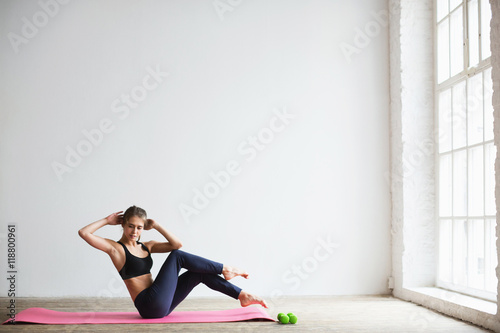 Portrait of young woman in sportswear, doing fitness exercise.