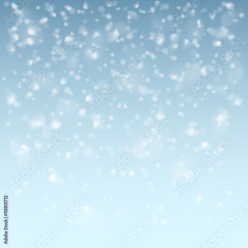 Falling flakes of snow on light blue background