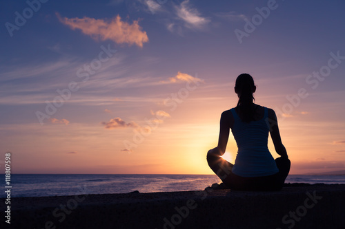 Woman relaxing by the beach watching the beautiful sunset. 