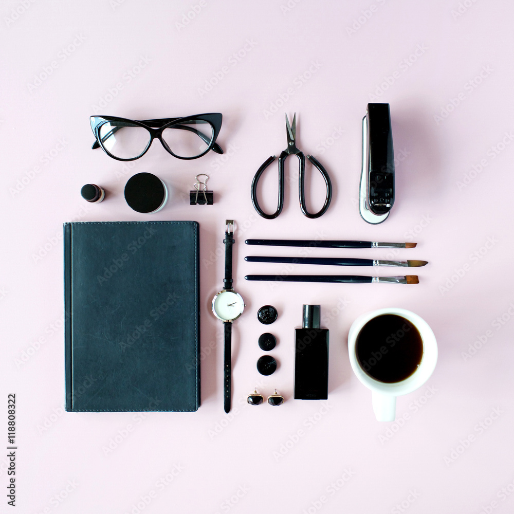 Flat lay, top view black style office table desk. feminine working supplies: glasses, diary, watches, perfume, brushes, scissors, coffee on pink background. Flat lay, top view black style office table desk. feminine working supplies: glasses, diary, watches, perfume, brushes, scissors, coffee on pink background.