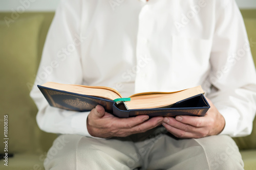 An old man hands holding the Koran. Selective focus © Ravil Sayfullin