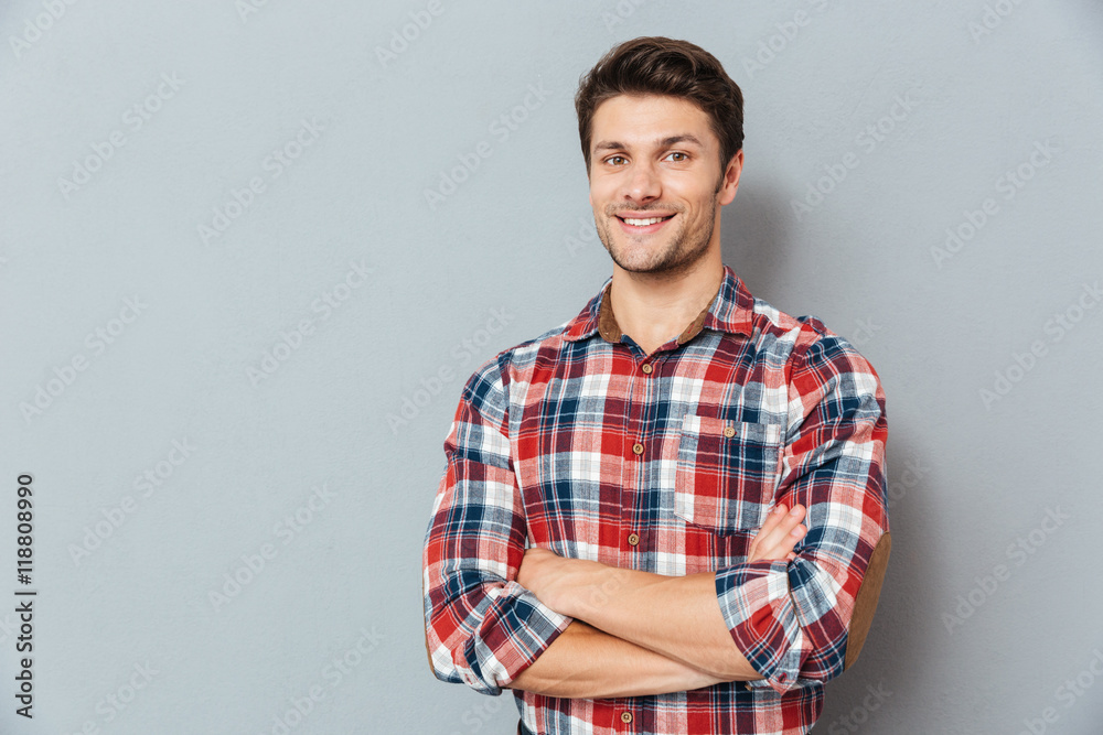 Portrait of a man with arms folded over gray background Portrait of a man with arms folded over gray background
