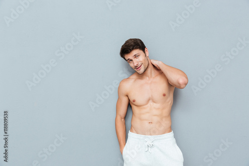 Attractive shirtless young man standing and posing
