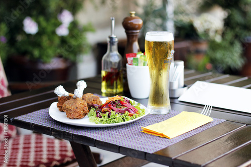 Tasty chiken  salad and beer on a plate at the restaurant terrace