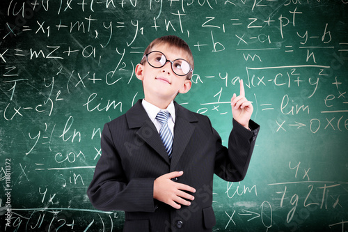 Little schoolboy on chalkbo...