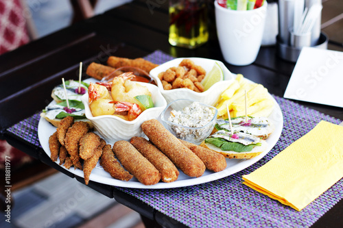 Nibbles sharer plate. King Prawns, Baby shrimps in bread crumbs, anchovies on toast bread ,fish fingers, crab sticks in bread crumbs,sardines in bread crumbs.At the restaurant .