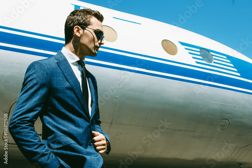 Handsome young man with short hair wearing classic blue suit and photo