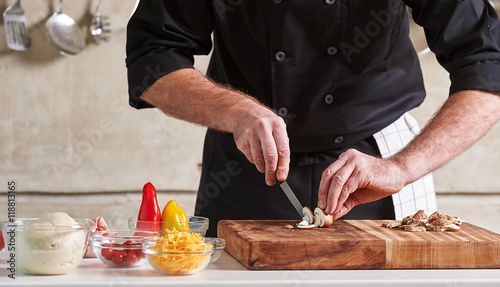 Restuarant hotel private chef cutting mushrooms on board