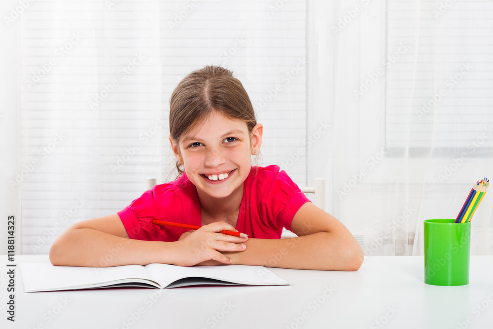 Cute little girl enjoys drawing and writing at her home. Cute little girl enjoys drawing and writing at her home.