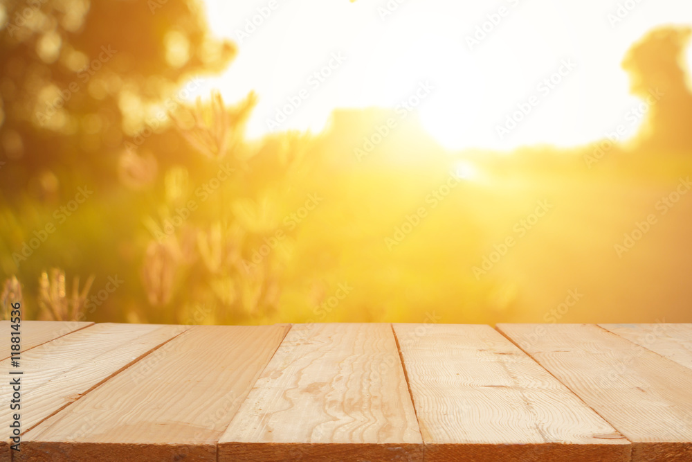 Empty wooden table with autumn for a catering or food background with a country outdoor theme,Template mock up for display of product,Blurred grass in bright morning. - obrazy, fototapety, plakaty 