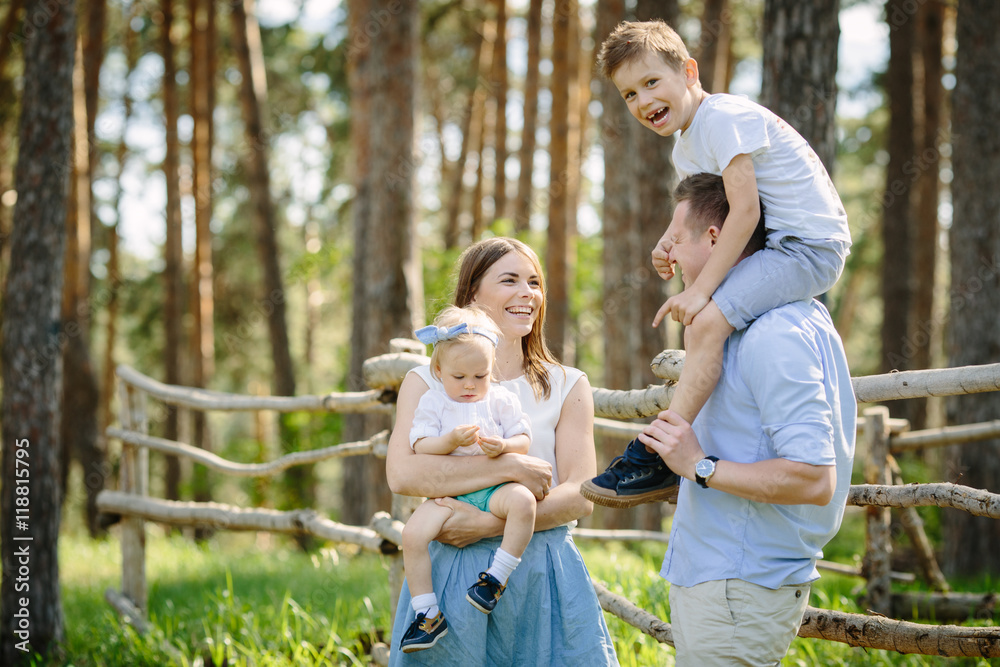 Fototapeta premium Portrait of beautiful family of four people mother father son daughter talking park near forest