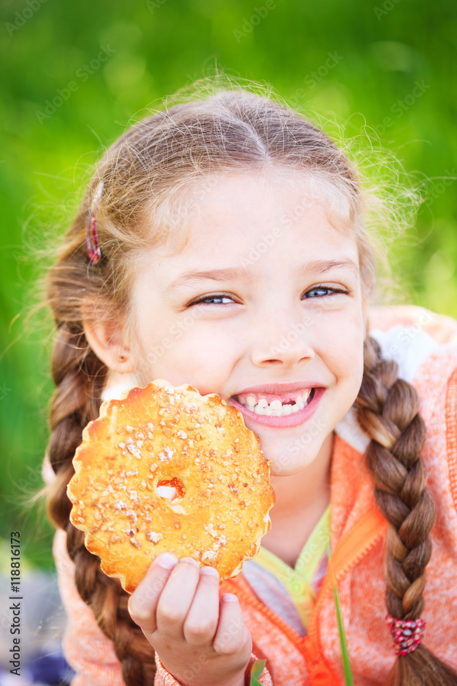 Sweet girl with a fallen toth holding cookies in her hand Sweet girl with a fallen toth holding cookies in her hand