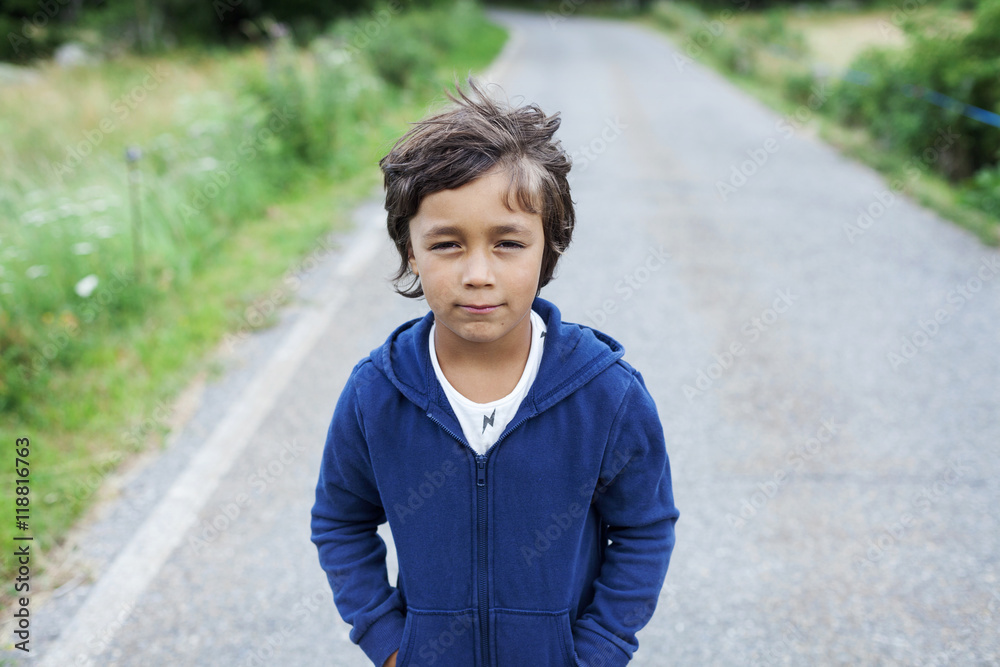 Portrait of little boy standing on a country road Portrait of little boy standing on a country road