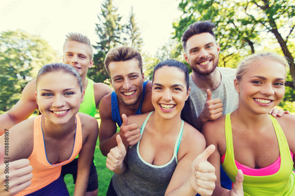 group of happy sporty friends showing thumbs up group of happy sporty friends showing thumbs up