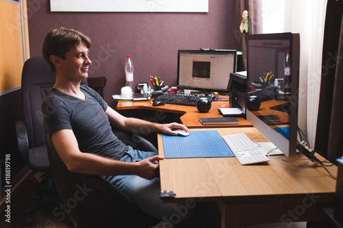 Young man at home using a computer, freelance developer or designer working