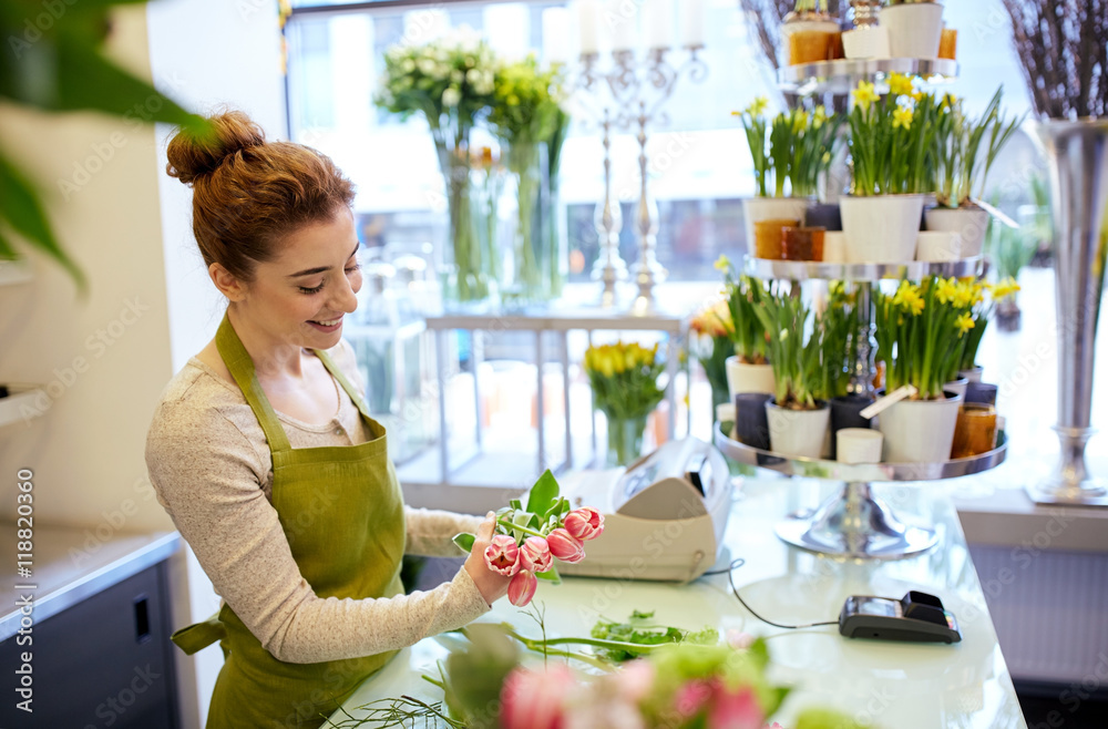 smiling florist woman making bunch at flower shop - obrazy, fototapety, plakaty 