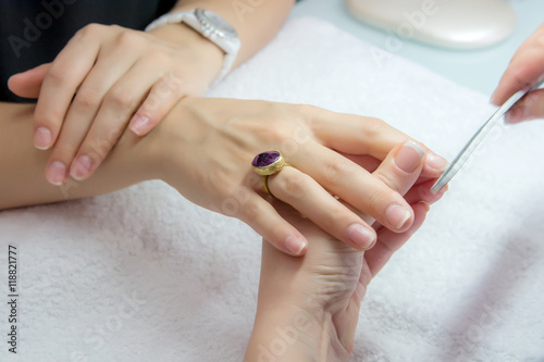 Woman hands in a nail salon receiving a manicure by a beautician