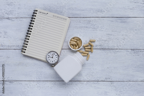 Time for pill, list for medicine time, blank notebook with herbal pill and vintage watch
