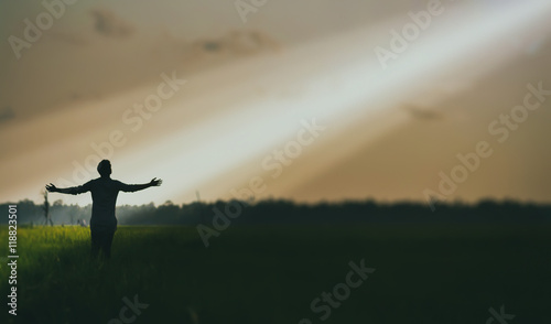 Man standing with arms outstretched in the Tribes on the background of the sun's rays photo