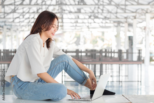 Woman sitting on the table playing laptop computer Free Download Woman sitting on the table playing laptop computer - GFXLoad
