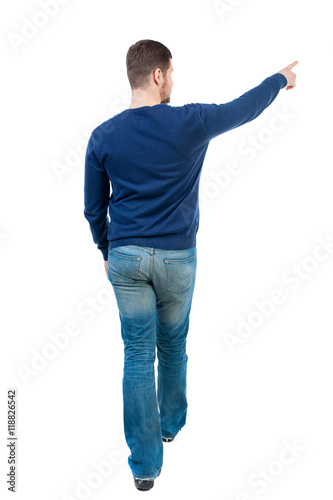 Back view of pointing business man. Rear view people collection. backside view of person. Isolated over white background. bearded man in blue pullover is pointing sideways.