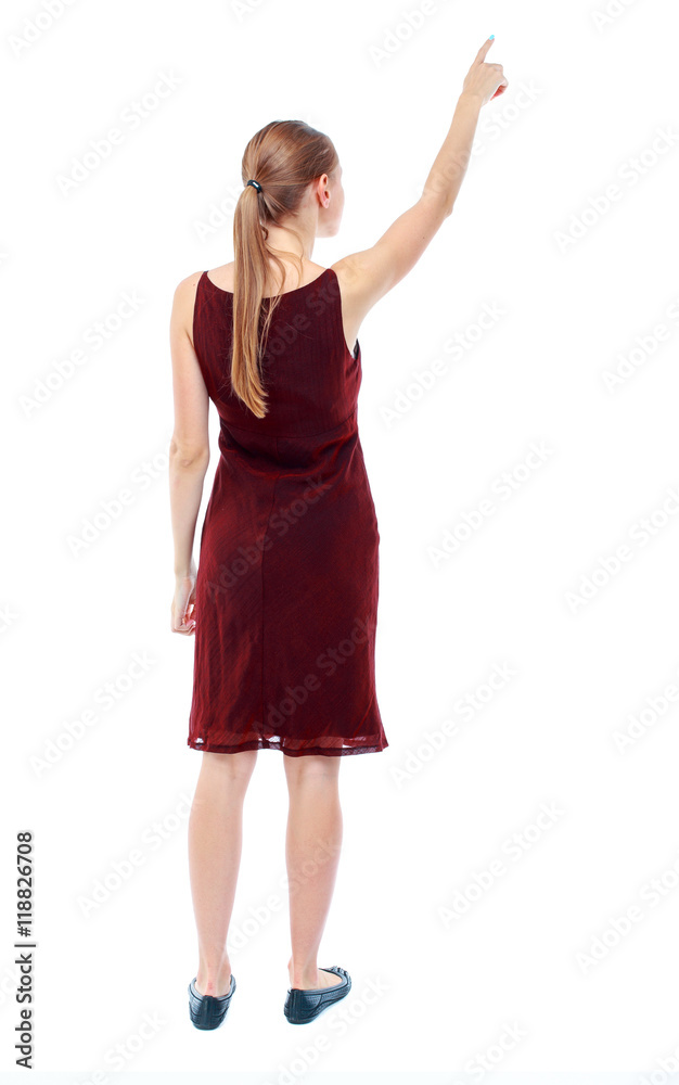 Back view of pointing woman. beautiful girl. Rear view people collection. backside view of person. Isolated over white background. The girl in the maroon sleeveless dress shows a finger to the sky. Back view of pointing woman. beautiful girl. Rear view people collection. backside view of person. Isolated over white background. The girl in the maroon sleeveless dress shows a finger to the sky.