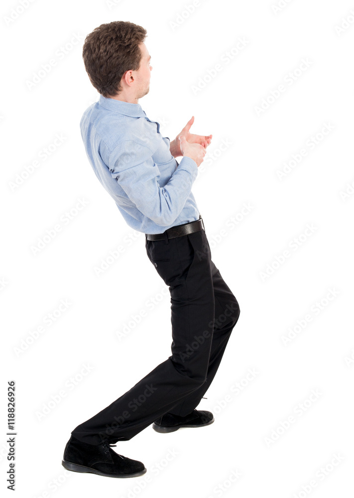 back view of standing man pulling a rope from the top or cling to something. Rear view people collection. backside view of person. Isolated over white background. The curly-haired businessman in back view of standing man pulling a rope from the top or cling to something. Rear view people collection. backside view of person. Isolated over white background. The curly-haired businessman in