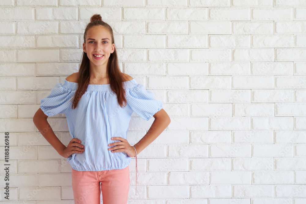 Smiling pretty girl with arms on hips against white background Smiling pretty girl with arms on hips against white background