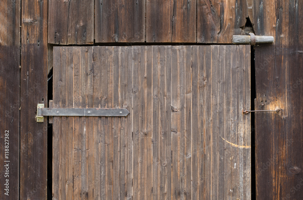 detail of a an old weathered wooden barn door with metal hinge detail of a an old weathered wooden barn door with metal hinge