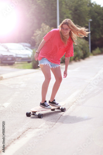 Skatergirl surft im Sonnenschein photo