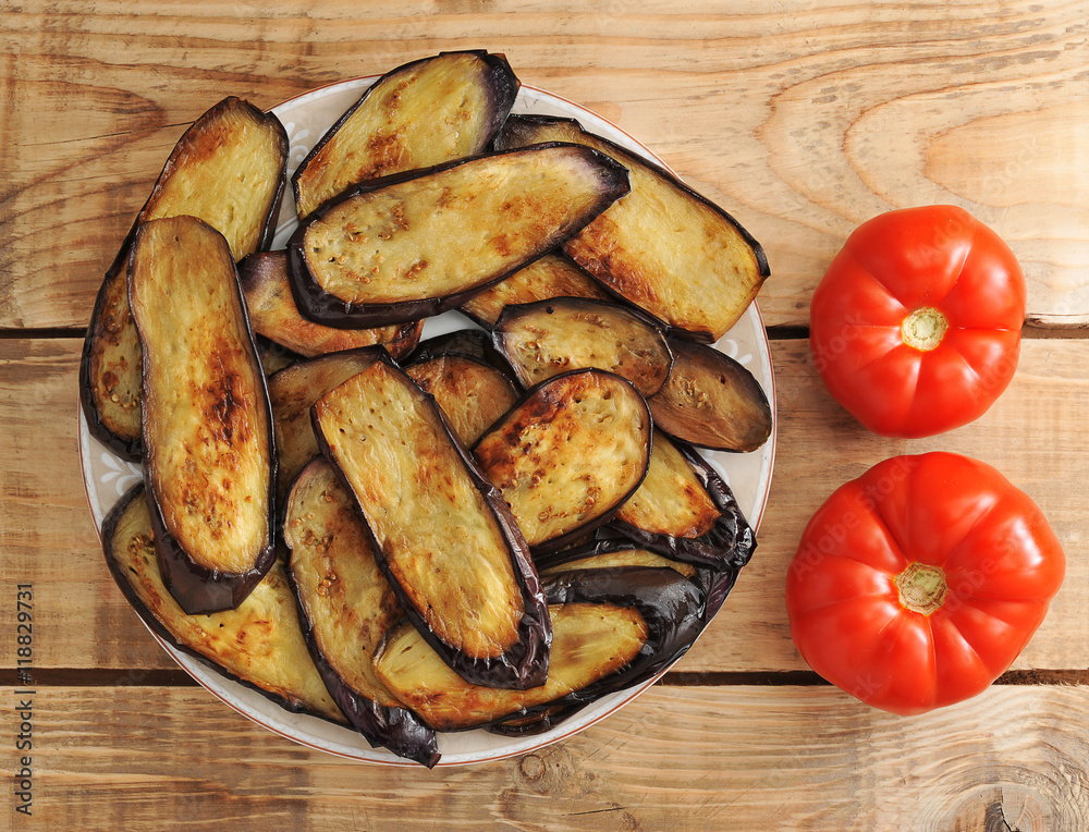 fried eggplant on the plate and two tomatoes fried eggplant on the plate and two tomatoes