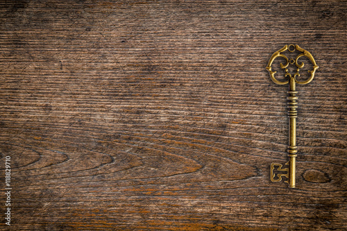Vintage key on wood texture and background with space.