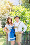 Couple in traditional bavarian clothes standing in the garden