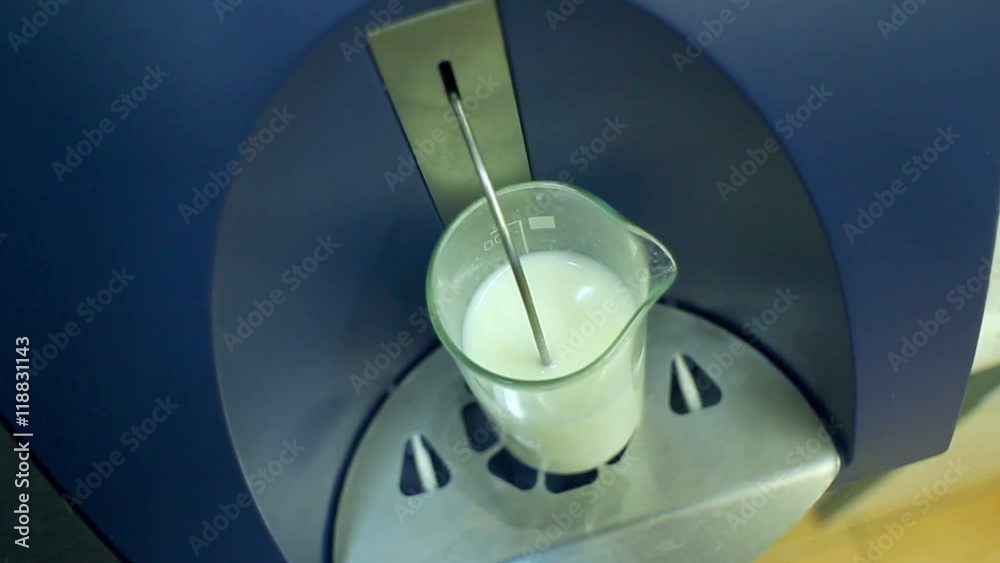 Glass with milk in laboratory equipment for testing dairy products
