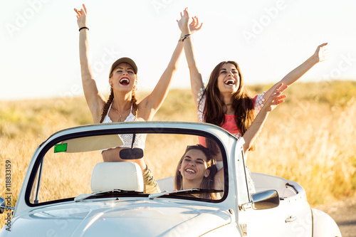 Three pretty young women driving on road trip on beautiful summe © nenetus