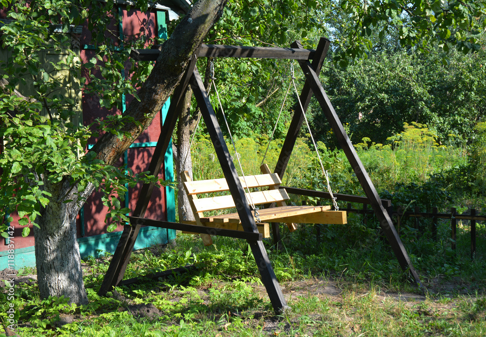 Wooden Garden Swing. Garden Swing Seat in tree shadow light. Wooden Garden Swing. Garden Swing Seat in tree shadow light.