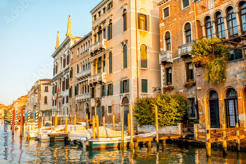 Beautiful waterfront with colorful gothic buildings and boats on Gran canal at the sunrise