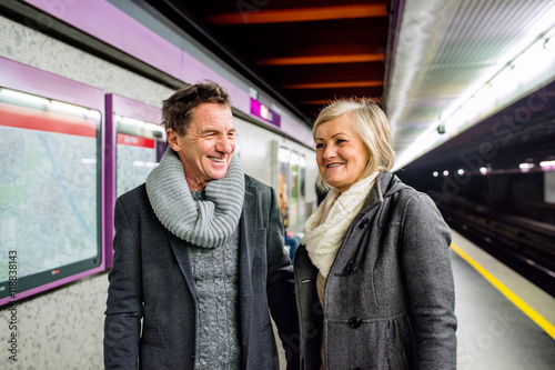 Senior couple standing at the underground platform  waiting