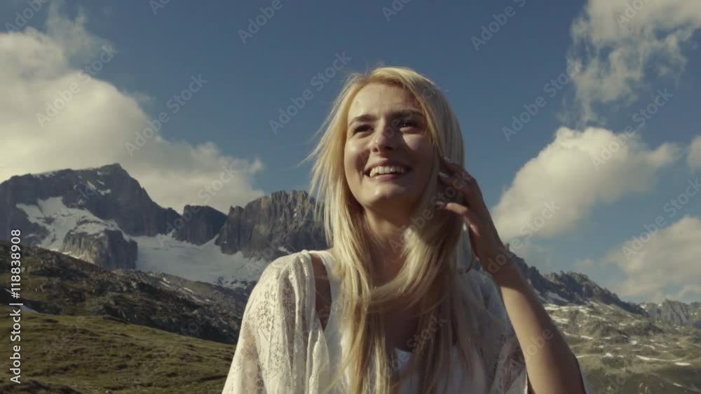Gorgeous blondie is smiling to the sunshine, while walking in the mountains. Attractive girl smiles. Gorgeous blondie is smiling to the sunshine, while walking in the mountains. Attractive girl smiles.