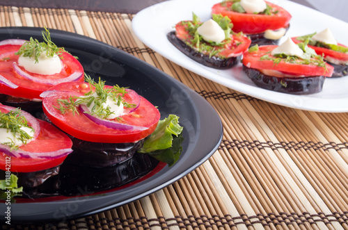 Vegetable dishes of stewed eggplant and fresh red tomato close-u