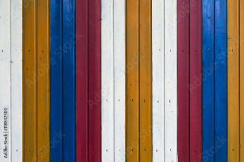 Bunte Holzwand / Hintergrund aus einer bunten Holzwand gestreift weiss, gelb, blau, rot.