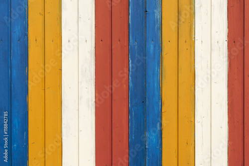 Bunte Holzwand / Hintergrund aus einer bunten Holzwand gestreift weiss, gelb, blau, rot.
