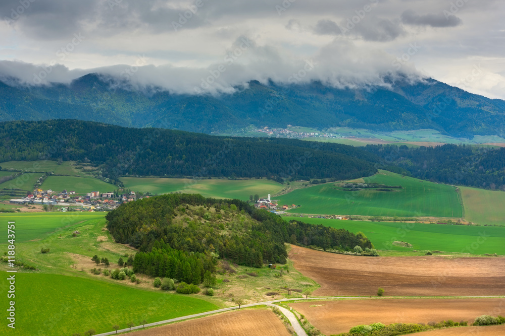 View of the agriculture fields, village, forests and mountains, sky with mystic clouds