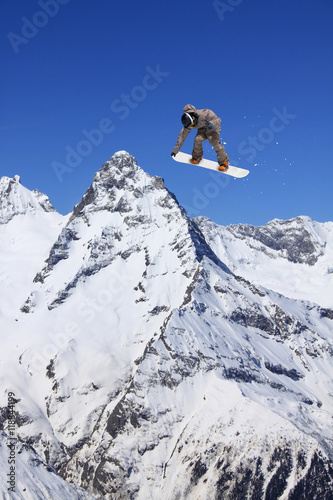 Snowboarder jumping on mountains. Extreme sport.