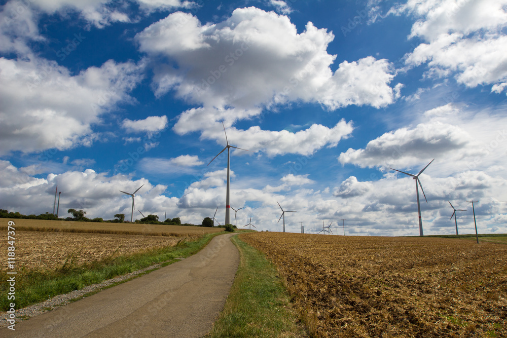 Windmill generator in wide yard / Yard of windmill power generatorunder blue sky, shown as energy industry concept Windmill generator in wide yard / Yard of windmill power generatorunder blue sky, shown as energy industry concept
