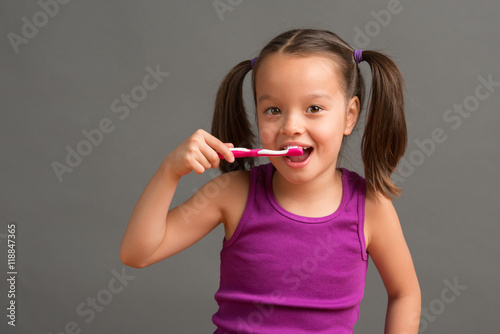 5 year old kid brushing her teeth