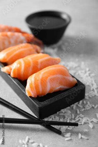 Salmon sushi on black wooden plate, closeup