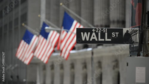Wall Street sign with flags purposely blurred in background, lower Manhattan, downtown New York City, HD video