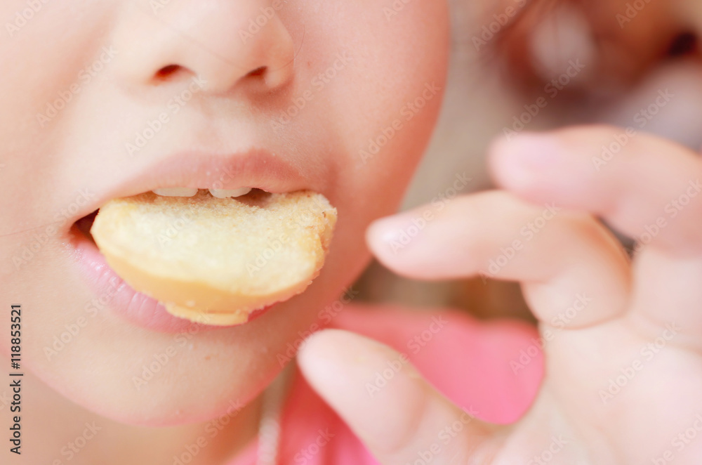 Young funny girl eating cookie and shows delicious expression,yummy cookie.Soft focus and pink color toned. Young funny girl eating cookie and shows delicious expression,yummy cookie.Soft focus and pink color toned.
